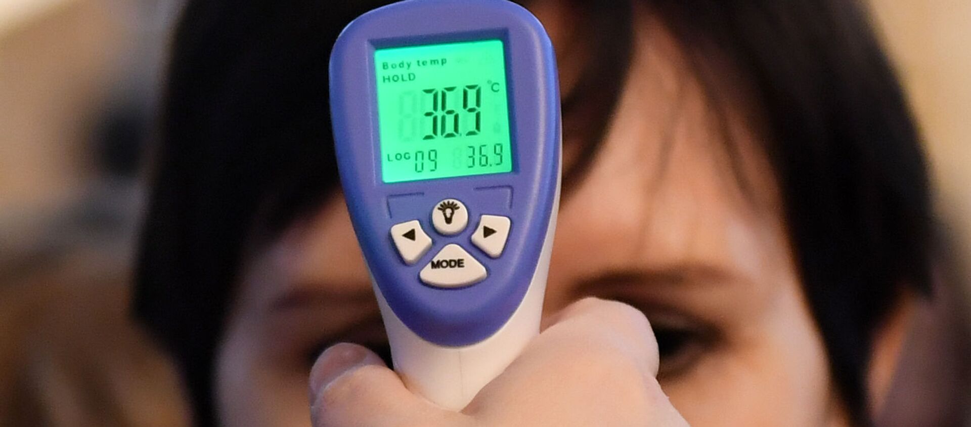 Женщине измеряют температуру в связи с угрозой распространения коронавирусной инфекции. - Sputnik Тоҷикистон, 1920, 31.01.2021