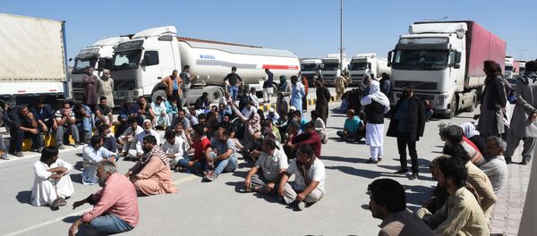 Водители грузовиков сидят на дороге возле закрытой ирано-пакистанской границы - Sputnik Таджикистан