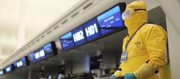Работник в защитном костюме в аэропорту Уханя Работник в защитном костюме в аэропорту Уханя - Sputnik Тоҷикистон