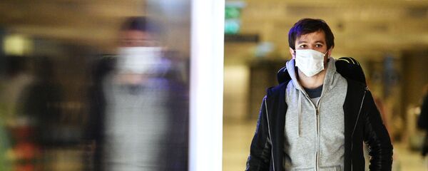 Молодой человек в медицинской маске в аэропорту Молодой человек в медицинской маске в аэропорту - Sputnik Тоҷикистон
