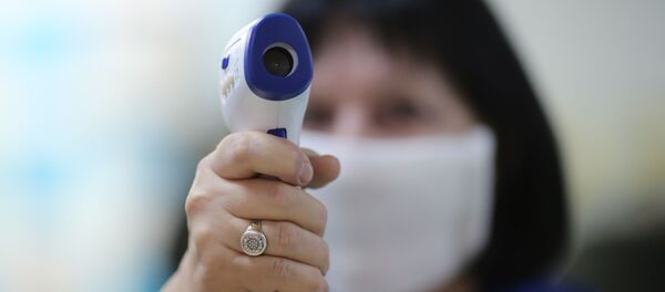 Сотрудница поликлиники готовится измерять температуру, архивное фото - Sputnik Тоҷикистон