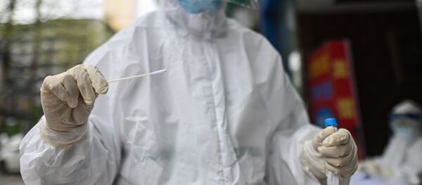 Медицинский работник берет образец мазка для тестирования на коронавирус COVID-19 - Sputnik Тоҷикистон