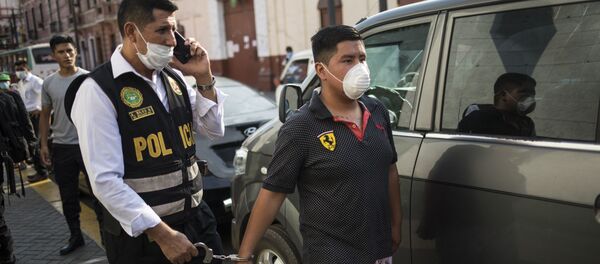 Полицейский в защитной маске ведет задержанного Полицейский в защитной маске ведет задержанного - Sputnik Таджикистан