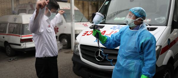  Сотрудник скорой медицинской помощи дезинфицируется в Тегеране, Иран - Sputnik Тоҷикистон