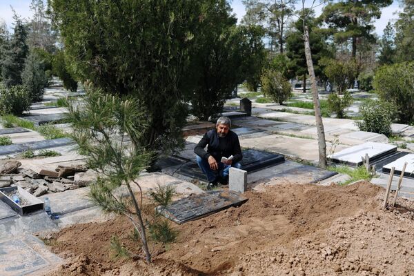 Родственник на могиле журналиста Abdollah Zavieh, умершего от коронавируса - Sputnik Таджикистан
