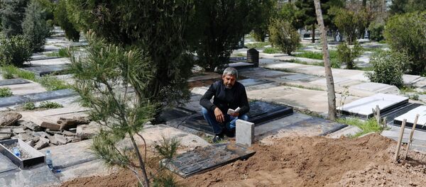 Родственник на могиле журналиста Abdollah Zavieh, умершего от коронавируса - Sputnik Тоҷикистон