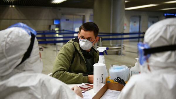 Медицинские работники во время проверки состояния пассажира в аэропорту Внуково - Sputnik Таджикистан