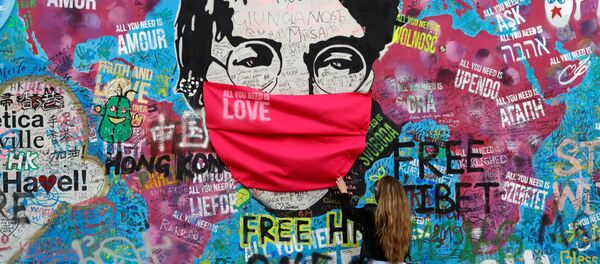 Женщина в маске у легендарной стены Джона Леннона в Праге Женщина в маске у легендарной стены Джона Леннона в Праге - Sputnik Таджикистан