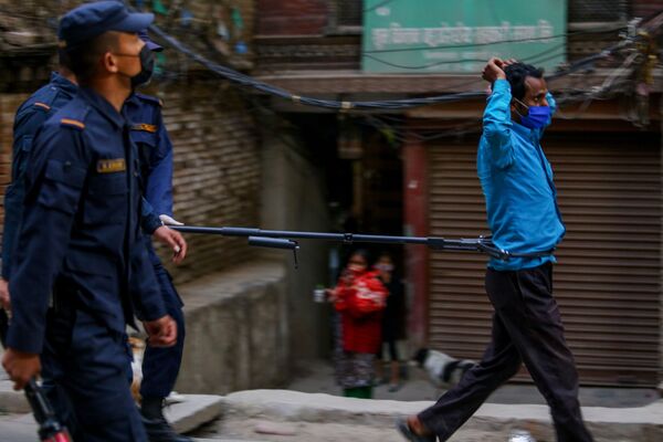 Полицейский во время задержания мужчины, нарушающего режим карантина, на одной из улиц Катманду - Sputnik Таджикистан