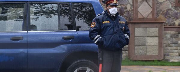 Сотрудник милиции в защитной медицинской маске - Sputnik Таджикистан