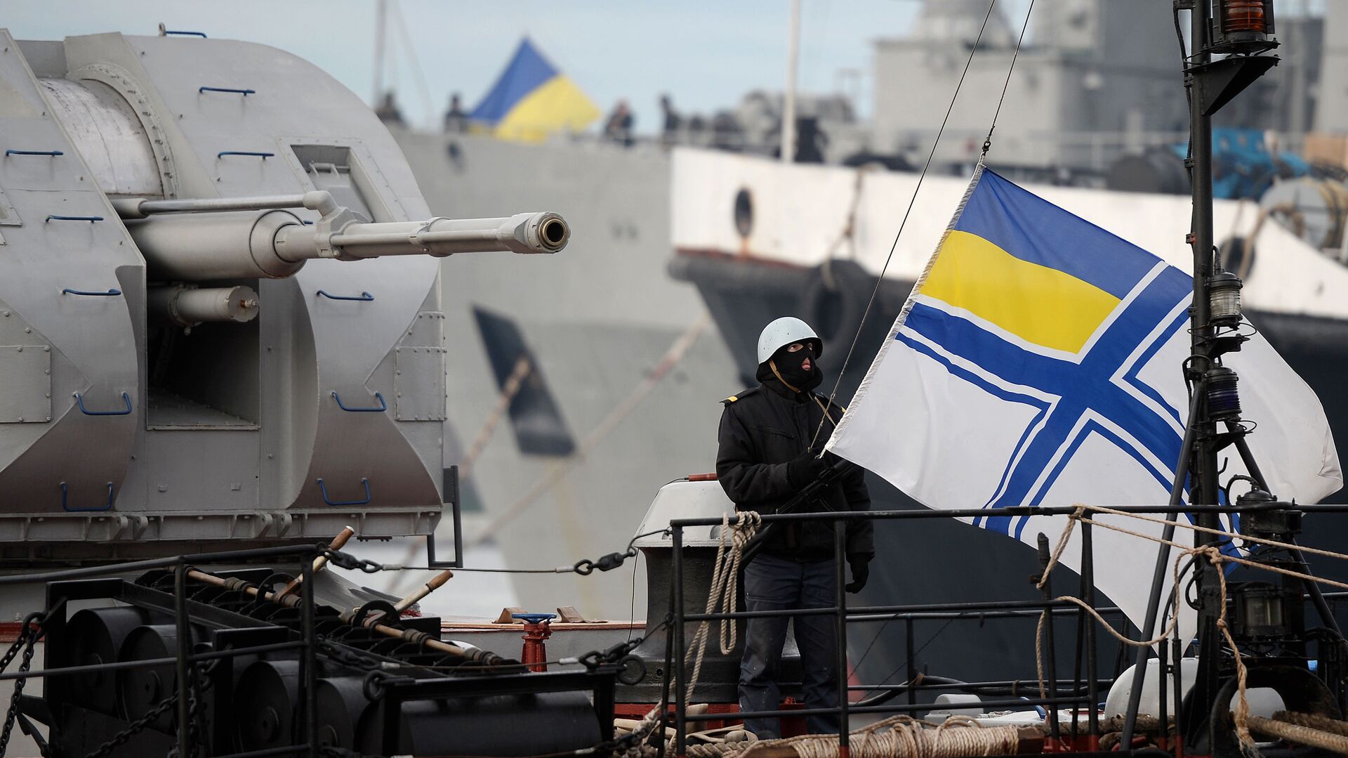 Украинский солдат поднимает флаг украинского военно-морского флота, стоя на страже на борту военного корабля - Sputnik Таджикистан, 1920, 08.04.2021