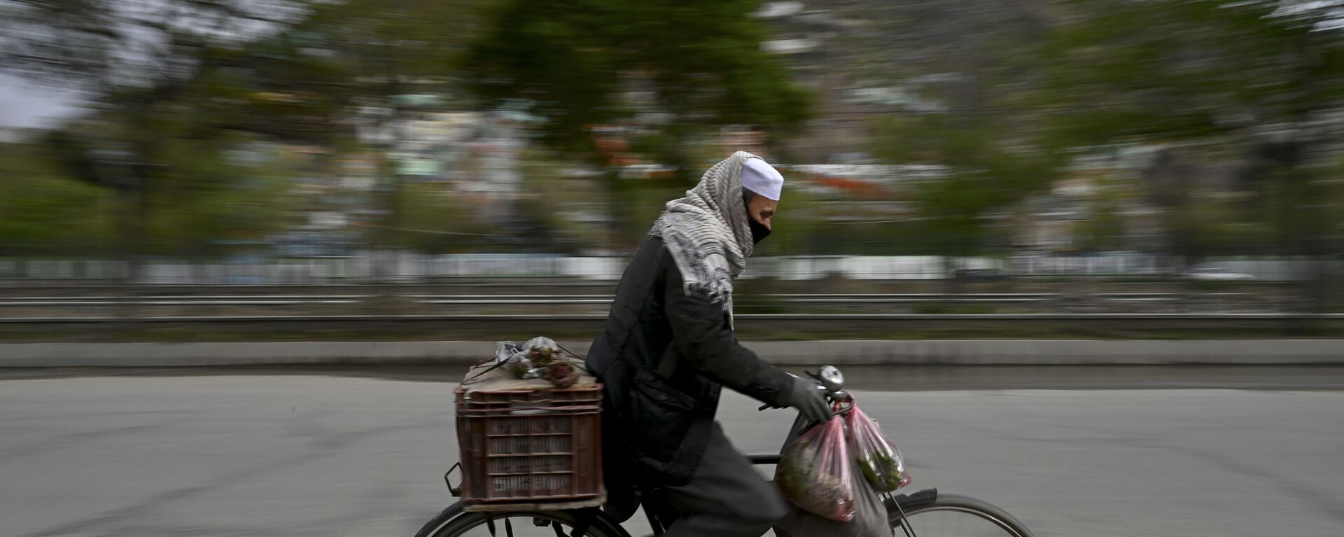 Мужчина в защитной маске едет на велосипеде по Кабулу, Афганистан - Sputnik Тоҷикистон, 1920, 04.11.2021