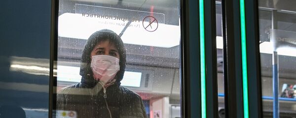 Женщина в защитной маске в вагоне поезда на станции метро Новокузнецкая в Москве - Sputnik Тоҷикистон