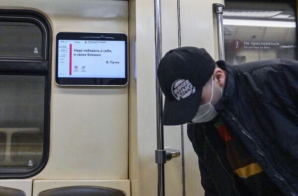 Курьер в защитной маске в вагоне поезда Московского метрополитена - Sputnik Таджикистан