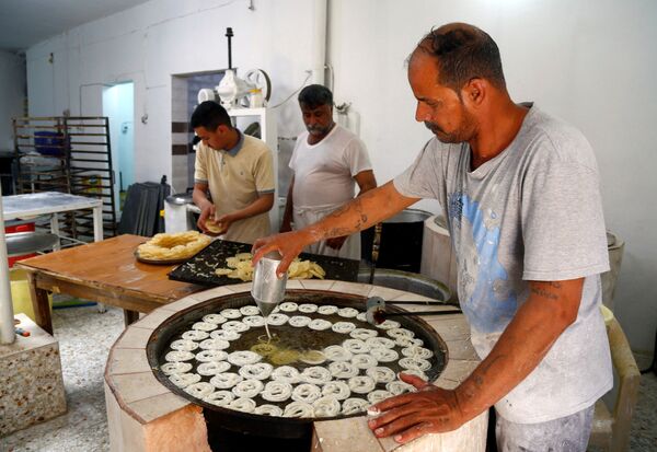 Приготовление традиционных сладостей для продажи в священный постный месяц Рамадан в Ан-Наджафе, Ирак - Sputnik Таджикистан