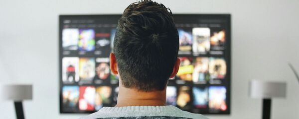 Мужчина смотрит телевизор - Sputnik Таджикистан