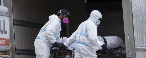 Медицинские сотрудники перевозят тела в рефрижераторный грузовик Медицинские сотрудники перевозят тела в рефрижераторный грузовик - Sputnik Тоҷикистон