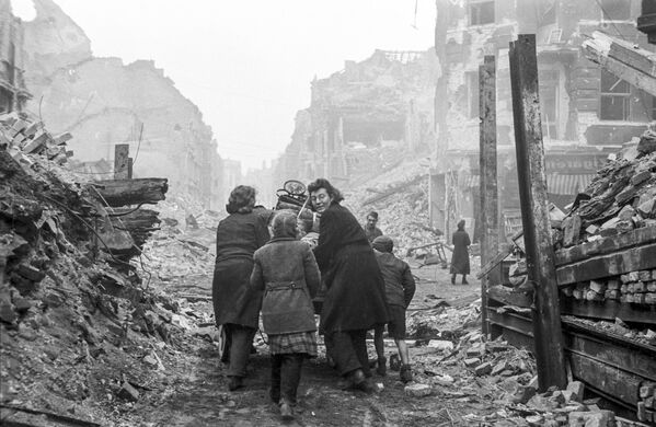 Жители Берлина возвращаются домой по заваленной обломками улице. Бои закончились. Май 1945 года - Sputnik Таджикистан