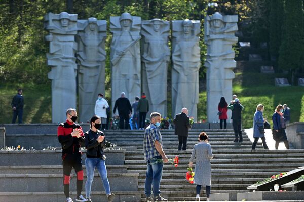 В Литве, несмотря на карантин, жители столицы отправились к мемориалам павших советских воинов, чтобы возложить цветы в честь их подвига (9 мая 2020). Вильнюс - Sputnik Таджикистан
