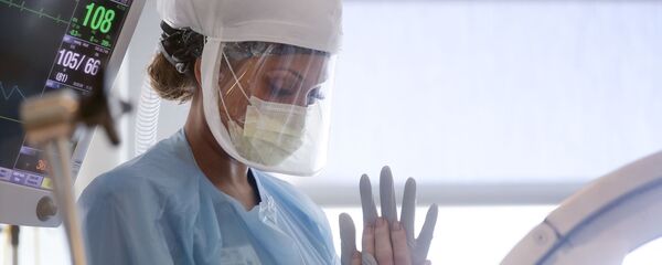 Медсестра выполняет ряд двигательных упражнений на пациенте с COVID-19 в больнице - Sputnik Тоҷикистон