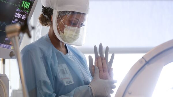 Медсестра выполняет ряд двигательных упражнений на пациенте с COVID-19 в больнице - Sputnik Тоҷикистон