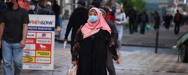 Женщина в защитной маске на улице города Душанбе Женщина в защитной маске на улице города Душанбе - Sputnik Таджикистан