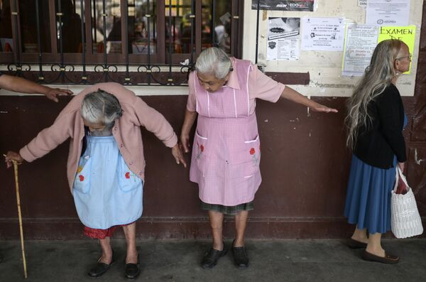 Женщины стоят в очереди на регистрацию по программе социальной помощи в Мексике - Sputnik Таджикистан
