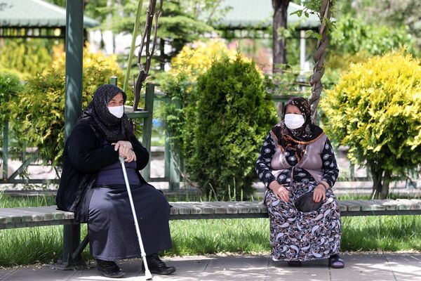 Пожилые женщины в медицинских масках на скамейке в одном из парков Анкары - Sputnik Таджикистан