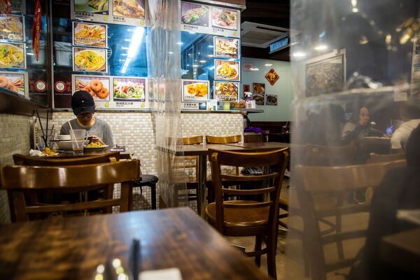Посетитель ресторана, разделенного пластиковыми шторками в Гонконге - Sputnik Таджикистан