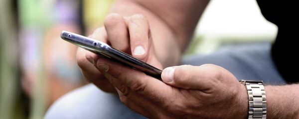 Человек держит мобильный телефон в руках, архивное фото - Sputnik Тоҷикистон