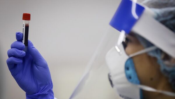 Медицинский работник держит в руках пробирку с биоматериалом - Sputnik Тоҷикистон