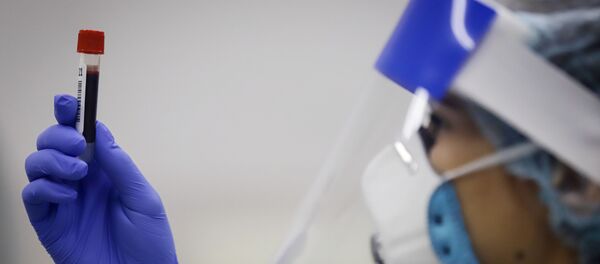 Медицинский работник держит в руках пробирку с биоматериалом - Sputnik Тоҷикистон