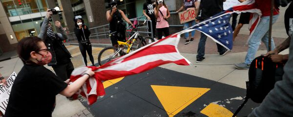 Протестующие рвут флаг США в Северной Каролине  - Sputnik Таджикистан