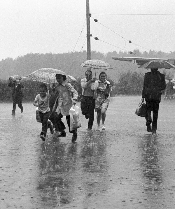 Жители города Тырныауз бегут под дождем. - Sputnik Таджикистан