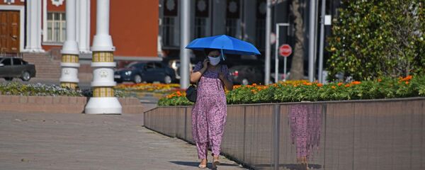 Женщина в защитной маске в центре Душанбе Женщина в защитной маске в центре Душанбе - Sputnik Таджикистан