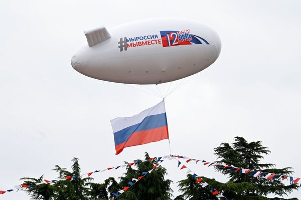 Аэростат, украшенный флажковой гирляндой цвета российского триколора, во время празднования Дня России в Сочи - Sputnik Таджикистан