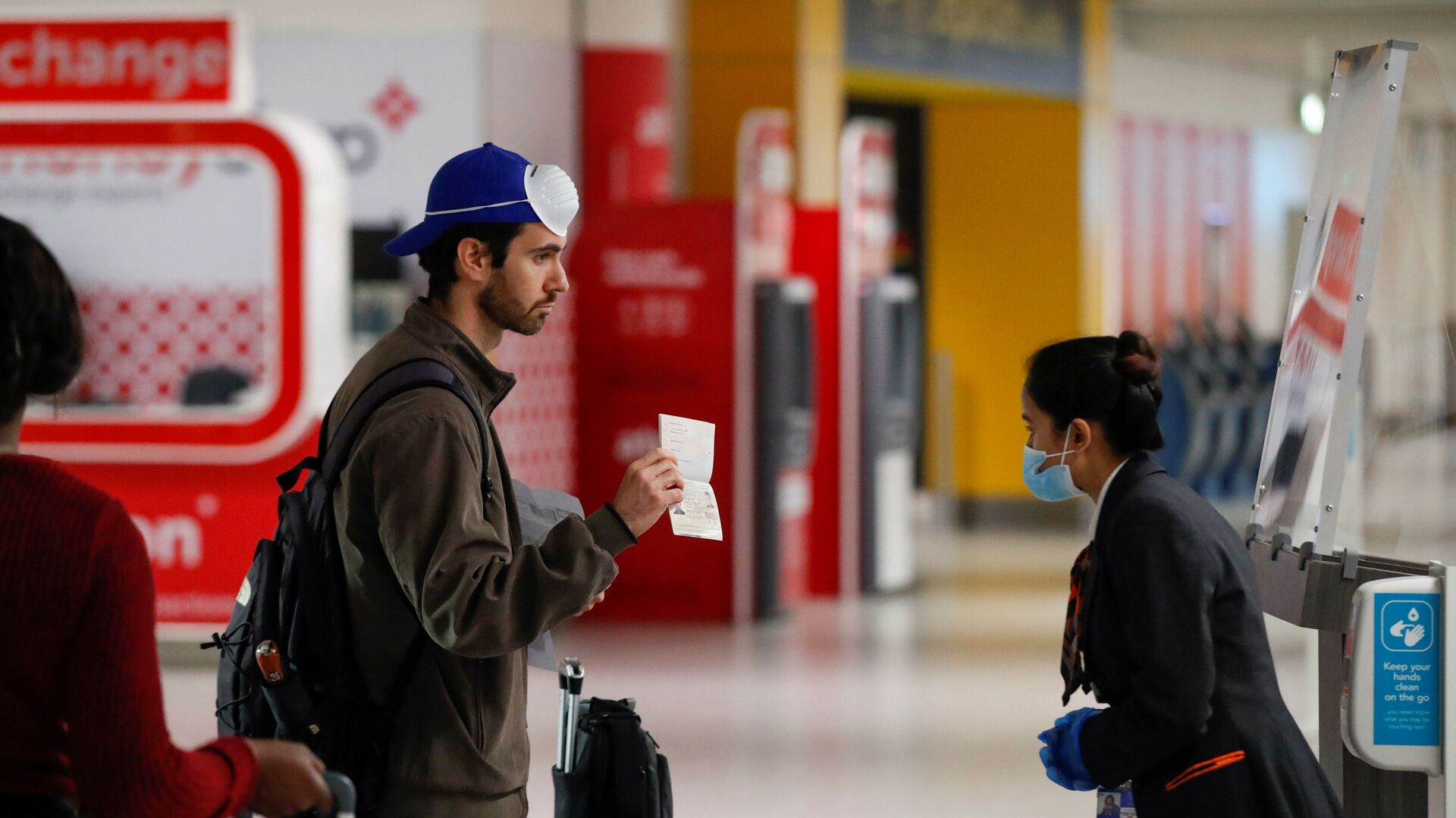 Пассажир предъявляет свой паспорт сотруднику в аэропорту Гатвик, Великобритания - Sputnik Таджикистан, 1920, 31.03.2021