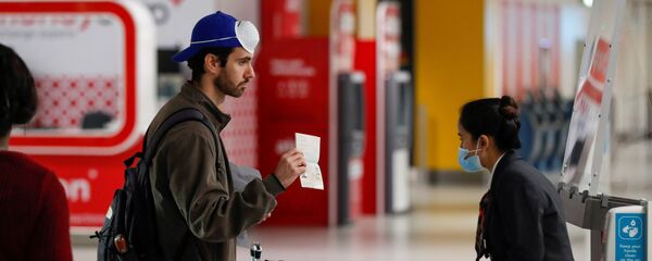 Пассажир предъявляет свой паспорт сотруднику в аэропорту Гатвик, Великобритания - Sputnik Таджикистан