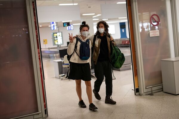  Пассажиры рейса из Амстердама в защитных масках прибывают в международный аэропорт в Афинах, Греция - Sputnik Таджикистан