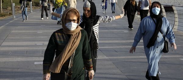 Люди в масках для лица тренируются на берегу искусственного озера в Западном Тегеране - Sputnik Тоҷикистон