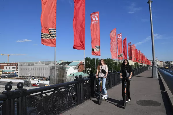 Девушки на самокатах на Большом Каменном Мосту в Москве