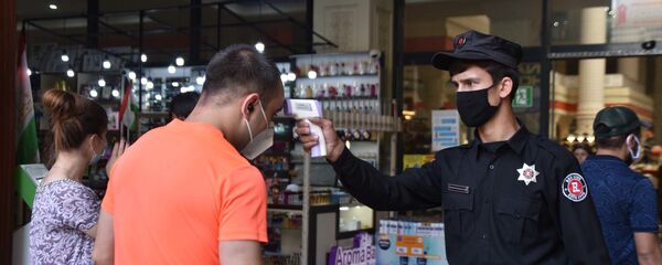 Сотрудник охраны рынка Мехргон проверяет температуру у посетителя - Sputnik Тоҷикистон