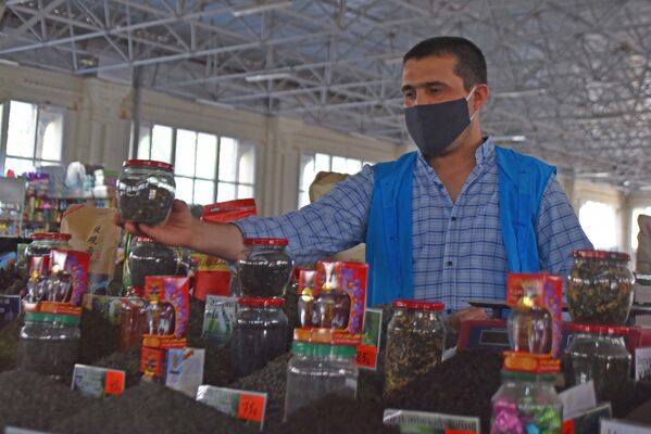 Продавец расставляет товары на рынке Мехргон - Sputnik Таджикистан