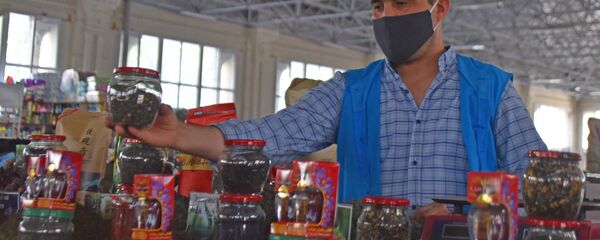 Продавец расставляет товары на рынке Мехргон Продавец расставляет товары на рынке Мехргон - Sputnik Таджикистан