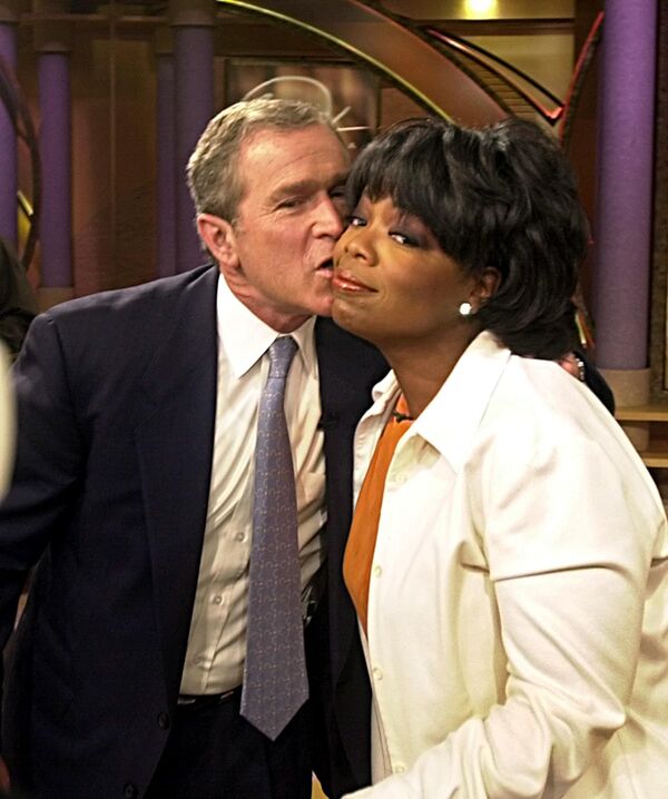 Кандидат в президенты США Джордж Буш-младший целует Опру Уинфри после выступления на ее шоу 19 сентября 2000 года в Чикаго - Sputnik Таджикистан