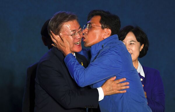 Кандидат в президенты Мун Чжэ Ин во время поцелуя однопартийца в Сеуле  - Sputnik Таджикистан