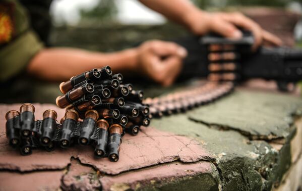 Военнослужащий мотострелкового полка Таманской дивизии снаряжает холостыми патронами  во время учений пулемет в Подмосковье - Sputnik Таджикистан